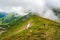 Group of hikers descending from top of Pietrosul Rodnei mountain. Mountain ridge slopes of Rodna Mountains National Park multiday