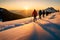 A group of hikers framed by the golden hues of a setting sun as they ascend a mountain ridge, casting long shadows