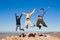 Group of hikers jumping on mountain summit