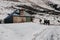 Group of hikers near the old building on the mountain covered with snow