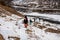 Group of hikers with snowboards hiking in mountains