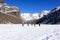 Group of hikers trekking in the mountains of the Alps. The trekkers are going through a snowy landscape