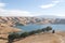 Group of horseback riders ride down trail at lake