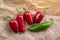 Group of hot peppers jalapeno, dark red color on creased beige brown paper, mexican cuisine very hot ingredients
