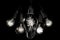 Group of incandescent light bulbs on black background with copy space. Generative AI