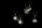 Group of incandescent light bulbs on black background with copy space. Generative AI