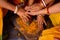 Group of Indian women holding a stone peace of mortar for making turmeric paste for wedding ceremony. Its a rituals of traditional