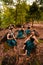 A Group of Indonesian dancers sitting gorgeously on the rock with brown leaves in the background inside the forest