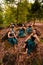 A Group of Indonesian dancers sitting gorgeously on the rock with brown leaves in the background inside the forest