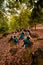 A Group of Indonesian dancers sitting gorgeously on the rock with brown leaves in the background inside the forest