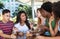 Group of international young adults in discussion in restaurant