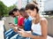 Group of international young adults typing message at phone