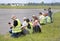 Group of journalists and photographers sitting on the airfield making report of the air show