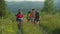 Group of joyful multiracial travelers with backpack ascending mountain hill