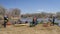 A group of kayakers is resting on a sandbar after dam portage during springtime paddling trip on