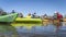 A group of kayakers is resting on a sandbar after dam portage during springtime paddling trip on