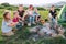 Group of Kids - Boys and girls cheerfully smiling and roasting sausages on long sticks over a campfire flame. Outdoor active time