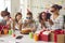 Group of kids celebrating their friend`s birthday and clapping hands as she`s blowing the candles