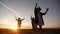 group of kids dancing in the park silhouette at sunset. kid dream fun party concept. children dancing in nature at