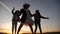 group of kids dancing in the park silhouette at sunset. kid dream party concept. children dancing in nature at sunset