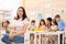 Group of kids and educator doing handcrafting together in classroom in kindergarten