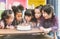 Group of kids enjoying a birthday party blowing out the candle on cake.