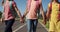 Group of kids holding hands while walking on the road