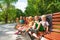 Group or kids rest on bench in park