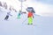 Group of kids ski downhill on Alpine resort