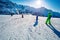 Group of kids ski downhill in the mountains