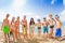 Group of kids in swimsuits standing on sandy beach