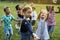 Group of kindergarten kids friends playing blowing bubbles fun