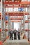 Group of large contemporary warehouse workers in gloves, respirators and uniform