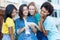 Group of latin and hispanic and african american girls watching movie clip at cellphone