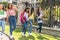 Group of Latina teen friends students walking with their backpacks, notebooks, laptop and cell phone on their way to high school.