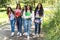 A group of Latina teenage women walk to class with backpacks, notebooks and cell phones