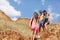 A group of laughing friends stands on a field, beautiful girls and boys on a vacation on a natural blurred background.