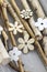 Group of light brown and white wooden flowers on gray birch branches on wooden table