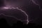 Group of lightning strikes caught on top of a forest during nighttime