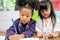 Group of little preschool kids drawing paper with color pencils . portrait of African girl with friends education concept.