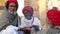 Group of local Indian men warming their hands by fire on the ground, closeup.