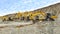 Group of machines with a hydraulic hammer mining rubble at the quarry