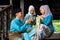 A group of malay muslim people in traditional costume showing greeting gesture during Aidilfitri celebration at terrace of