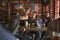 Group Of Male Friends Celebrating Whilst Watching Game On Screen In Sports Bar