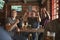 Group Of Male Friends Celebrating Whilst Watching Game On Screen In Sports Bar