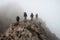 A group of male hikers with backpacks climb a rocky hill.