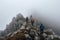 A group of male hikers with backpacks climb a rocky hill.