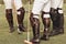 A group of male professional equestrian polo players in Leather brown high boots, protective knuckles, hammer and whiplash in the