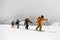 Group of male skiers with backpacks hiking on skis in snow. Skitour concept.