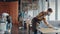 Group of male waiters in protective workwear spraying disinfectant on tables